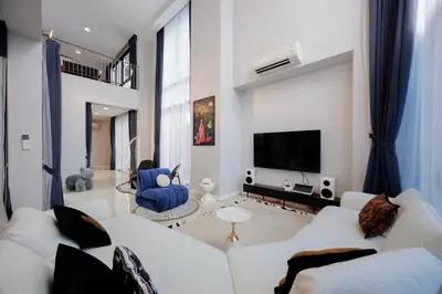 a living room with white furniture and a flat screen tv at \u66fc\u8c37\u5e02\u4e2d\u5fc3\u4e03\u5367\u5ba4\u72ec\u680b\u8c6a\u534e\u6cf3\u6c60\u522b\u5885 in Bangkok