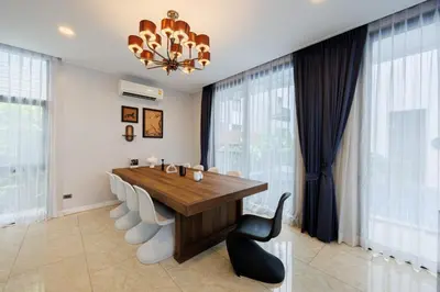 a dining room with a wooden table and a chandelier at \u66fc\u8c37\u5e02\u4e2d\u5fc3\u4e03\u5367\u5ba4\u72ec\u680b\u8c6a\u534e\u6cf3\u6c60\u522b\u5885 in Bangkok