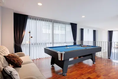 a pool table in a living room with a couch at \u66fc\u8c37\u5e02\u4e2d\u5fc3\u4e03\u5367\u5ba4\u72ec\u680b\u8c6a\u534e\u6cf3\u6c60\u522b\u5885 in Bangkok