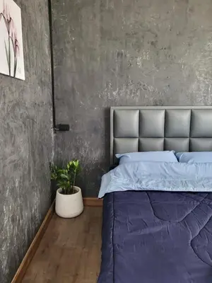a bedroom with a purple bed and a concrete wall at auntythong house in Bangkok