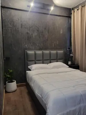 a bedroom with a large bed with a black wall at auntythong house in Bangkok