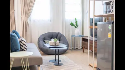 a living room with a grey chair and a table at 3A-168 House Near BTS-icon siam in Godown