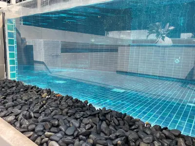 a swimming pool with a bunch of rocks around it at Delight Home in Amphoe Phra Khanong
