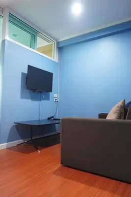 a living room with a couch and a flat screen tv at Regent Srinakarin 19A in Bangkok