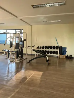 a gym with a bench and equipment in a room at Regent Srinakarin 19A in Bangkok