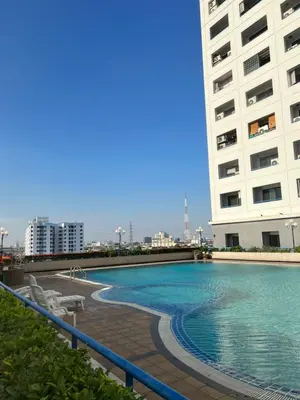 a large swimming pool next to a tall building at Regent Srinakarin 19A in Bangkok