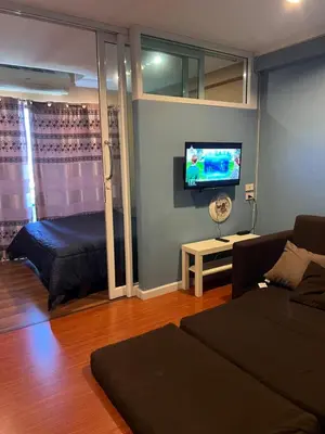 a living room with a couch and a bed and a tv at Regent Srinakarin 19A in Bangkok