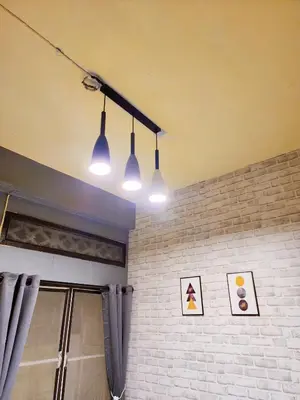 a room with three lights and a brick wall at 110-Olan Place Homely room Free Wi-Fi and Near BTS line in Bangkok