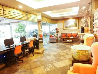a lobby with desks and chairs in a room at Best Comfort Bangkok Hotel in Bangkok