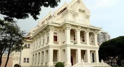 a large white building with red windows at J Two S Pratunam Hotel in Bangkok