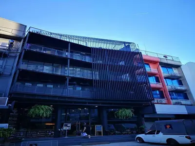 a building with a car parked in front of it at sook station in Bangkok