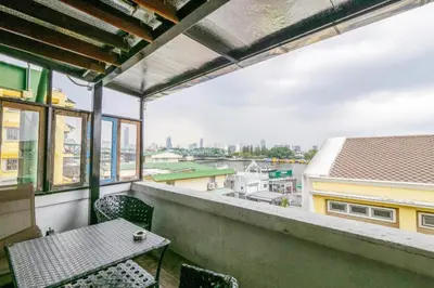a balcony with a table and chairs and a view at Art Hotel Sanamchai in Bangkok
