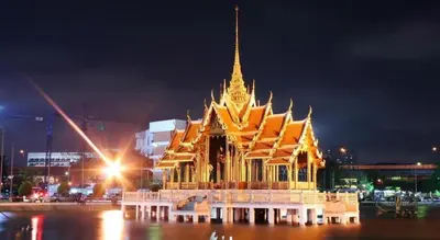 a large gold and white building at night at Town In Town Gardent Resort in Sathani Khlong Tan