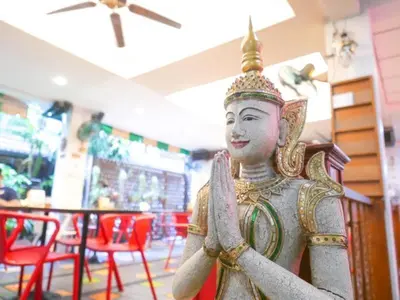 a statue of aitating person in a restaurant at New Siam Guest House in Bangkok