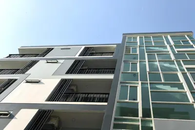 a tall apartment building with many windows at Home Inn Hotel in Bangkok