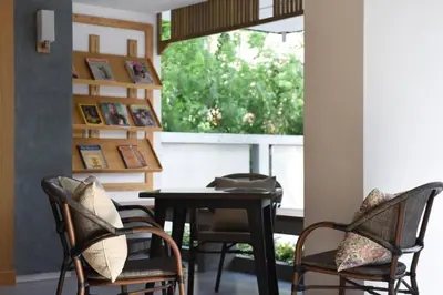 a dining room with chairs and a table and a window at Home Inn Hotel in Bangkok