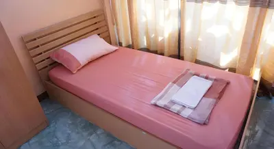 a pink bed with two towels on top of it at OYO 730 Meedee Hostel in Bangkok