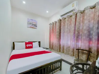a bedroom with a bed with a red pillow on it at OYO 253 KK 11 Boutique Inn in Bangkok