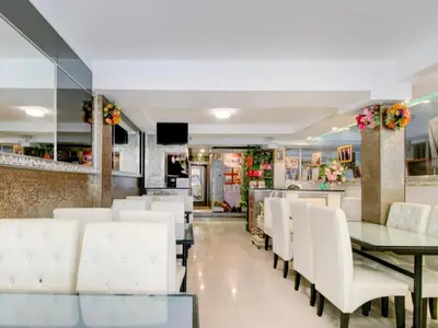 a dining room with white chairs and a table at OYO 253 KK 11 Boutique Inn in Bangkok