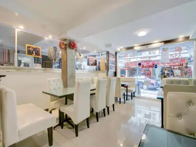 a dining room with a table and white chairs at OYO 253 KK 11 Boutique Inn in Bangkok