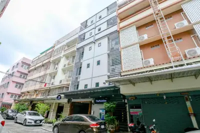 a tall building with cars parked in front of it at OYO 935 The Palm Apartment in Bangkok
