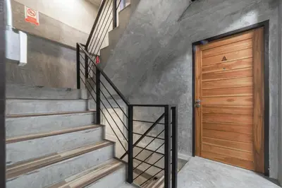 a stairway with a wooden door and a wooden stair railing at OYO 935 The Palm Apartment in Bangkok