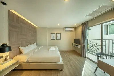 a hotel room with a bed and a balcony at Ralph Poshtel Pratunam in Bangkok