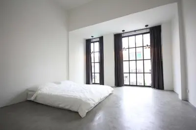 a white room with a bed and two windows at L22 HOSTEL in Ban Khlong Samrong