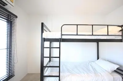 two bunk beds in a room with a window at L22 HOSTEL in Ban Khlong Samrong