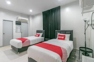 two beds in a room with red and white at OYO 818 Suksomboon Residence in Bangkok