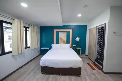 a bedroom with a large bed with blue walls at SkyLink Homes - Pattunaam - Airport Link & BTS Chidlom in Bangkok