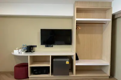 a living room with a tv in a room at Parcel Hotel Bangkok in Bangkok
