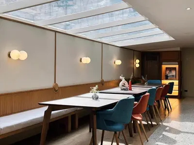 a dining room with tables and chairs and a skylight at Parcel Hotel Bangkok in Bangkok