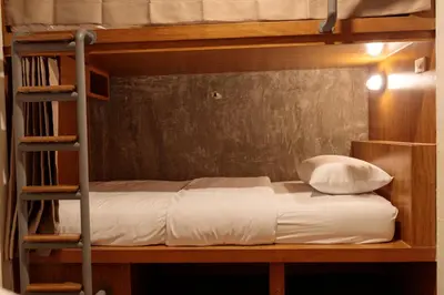 a bedroom with a bunk bed with a ladder at Rere Hostel - รีรีโฮสเทล in Bangkok