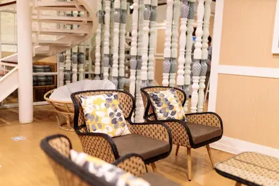 a group of chairs with pillows in a room at Rere Hostel - รีรีโฮสเทล in Bangkok
