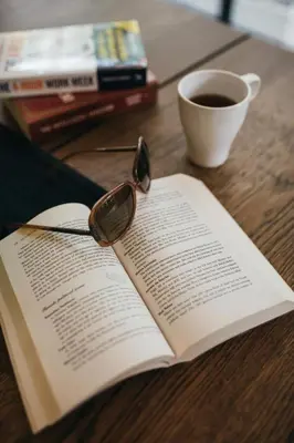 an open book with glasses and a cup of coffee at Chamberlain Bangkok in Bangkok