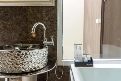 a bathroom with a sink and a bath tub at The Valen Resort in Bangkok