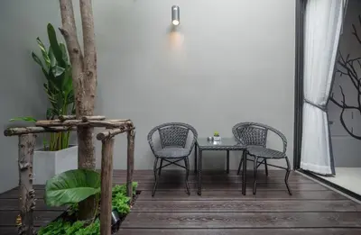a table and two chairs on a wooden deck at The Valen Resort in Bangkok