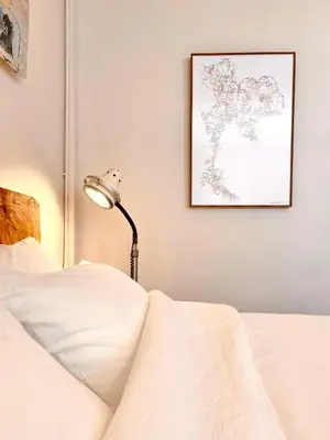 a bed with a lamp and a map on the wall at Mana Craft Stay in Bangkok