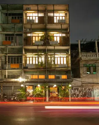 a building at night with a street in front of it at Mana Craft Stay in Bangkok
