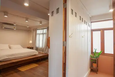 a bedroom with a bed and a large window at Mana Craft Stay in Bangkok