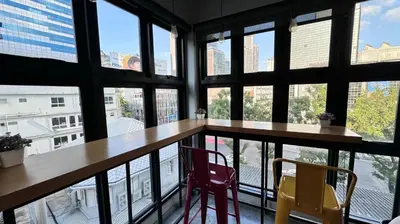 a table and two chairs in a room with windows at Bangkok Silom chat box hostel in Bangkok