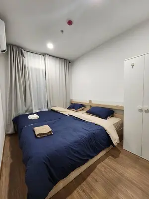 a bedroom with a large bed with blue sheets at Cozy Downtown Apartment - long stay in Bangkok- MRT Phasi charoen in Bangkok