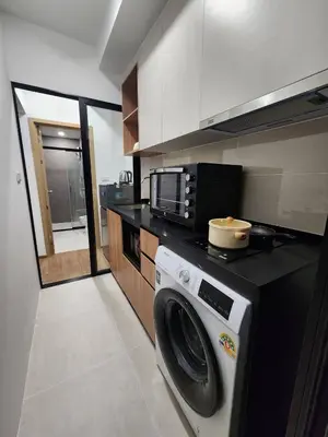 a kitchen with a washing machine and a microwave at Cozy Downtown Apartment - long stay in Bangkok- MRT Phasi charoen in Bangkok
