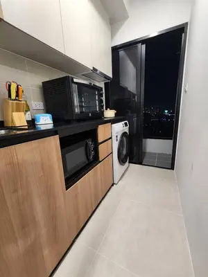 a kitchen with a microwave and a washer and dryer at Cozy Downtown Apartment - long stay in Bangkok- MRT Phasi charoen in Bangkok