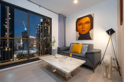 a living room with a couch and a large window at Luxury Art apt Downtown Metro Bangkok-Kitchen-living room in Bangkok