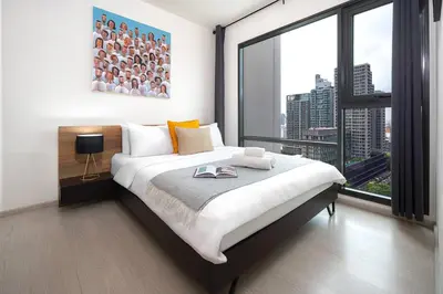 a bedroom with a bed and a large window at Luxury Art apt Downtown Metro Bangkok-Kitchen-living room in Bangkok