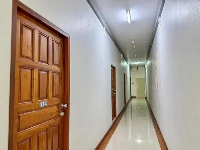 an empty hallway with a wooden door and a corridorngthngthngthngthngthngth at Nicha Residence Hotel in Bangkok