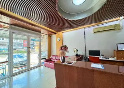 a living room with a red couch and a table at Nicha Residence Hotel in Bangkok