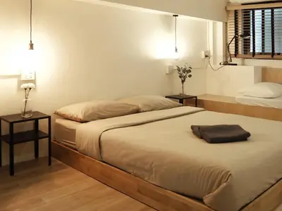 a bedroom with two beds and two night stands at Monomer Hostel Bangkok in Bangkok